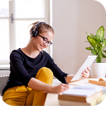 ヘッドホンで音楽を聴きながらデスクで趣味のプランを練る女性イメージ